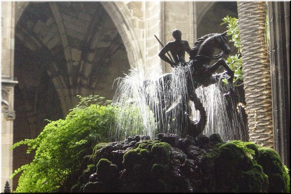 Cathedral cloister fountain. St. George and the dragon rise up out of a huge mound of soft green moss. 